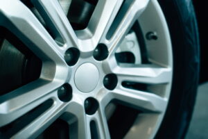Close-up of a sleek, modern silver alloy wheel with intricate spoke design, highlighting the metallic sheen and detail. The tone is polished and sophisticated.